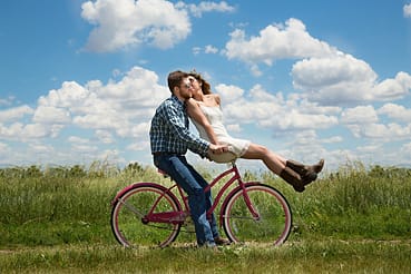 Um casal feliz numa bicicleta. Um poema sobre a vida.